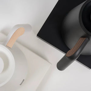 Közeli kép fekete és fehér elektromos vízforralóról fa részletekkel baristák és filterkávé kiegészítők számára a Timemore-tól