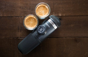 Hordozható eszpresszógép két csésze eszpresszóval fa felületen, hordozható kávéfőzők és barista felszerelések között